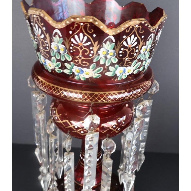 A striking pair of Victorian cranberry glass mantel lusters dating to approximately circa 1880–1895, beautifully hand-...