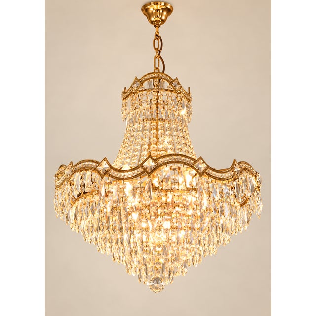 An exceptional and highly decorative monumental crystal chandelier, executed in the glamorous Hollywood Regency style and...