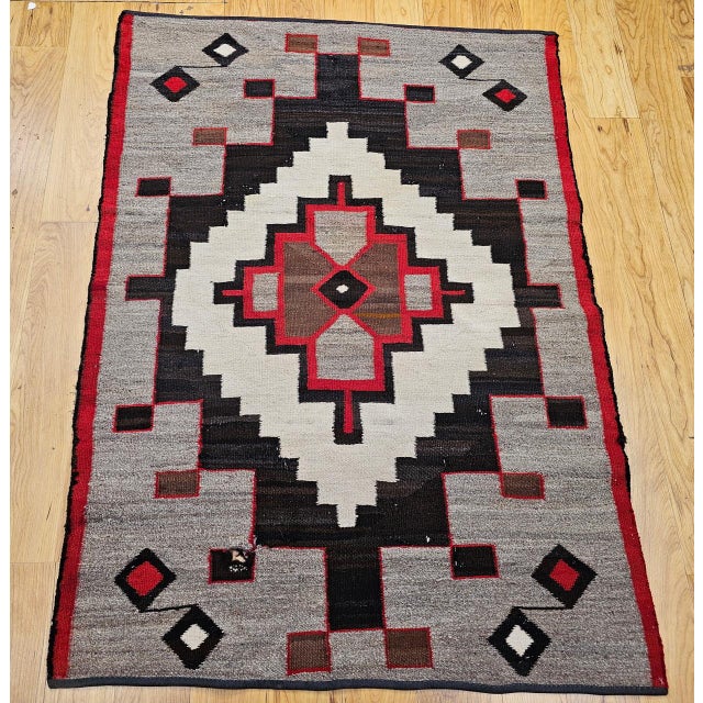 Early 20th-century Navajo area rug, handwoven in the American Southwest, this piece is a striking example of traditional...