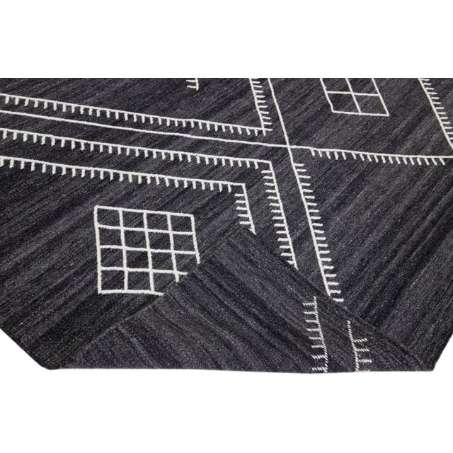 Beautiful kilim handmade wool rug with a gray-charcoal field. This custom modern flatweave rug of our Nantucket collection...