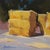 This oil on panel artwork features a serene depiction of stacked hay bales, their vibrant yellow hues contrasting against...