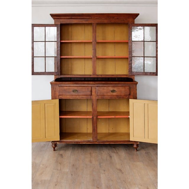 A beautifully proportioned 19th-century American stepback cupboard, crafted in warm pine and retaining its original wavy...