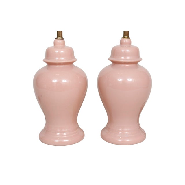 A pair of blush pink ceramic table lamps. Elegantly turned in a chinoiserie temple jar shape with a flared beveled base....