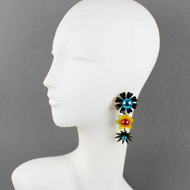 These stunning Kenzo Paris resin and glass pierced earrings feature a long dangling drop shape with a floral design built...