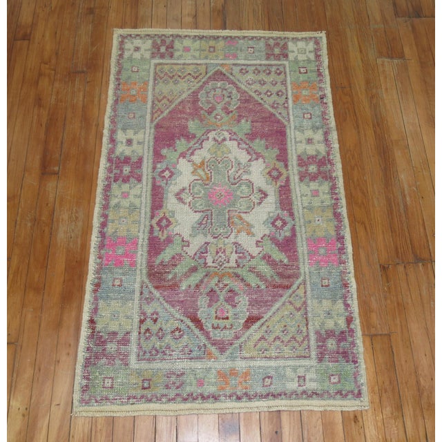 A pair of mid-20th century Turkish Anatolian rug mats with a lavender field pops of green and pink accents. One piece is 1...