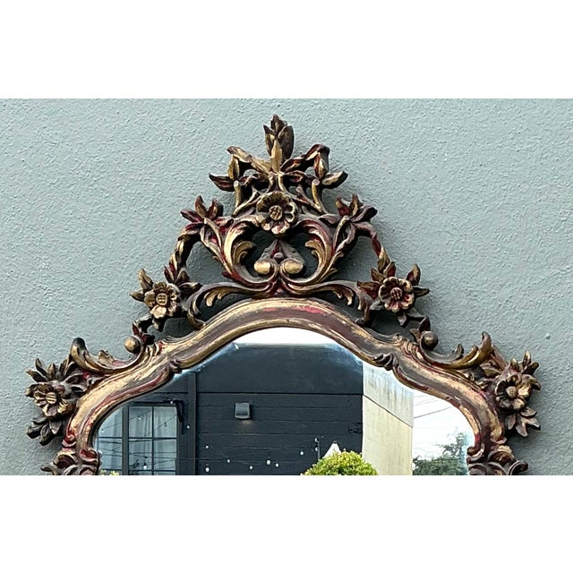 This vintage ornate carved wall mirror is a remarkable example of classical European-inspired craftsmanship, showcasing an...