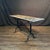 Elegant French bistro table featuring a long, narrow lovely early marble top raised on a classic Provencal slender black...
