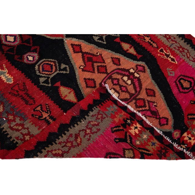 Beautiful vintage Turkish Kilim hand-knotted wool rug with a pink field. This piece has a gray frame and multicolor...