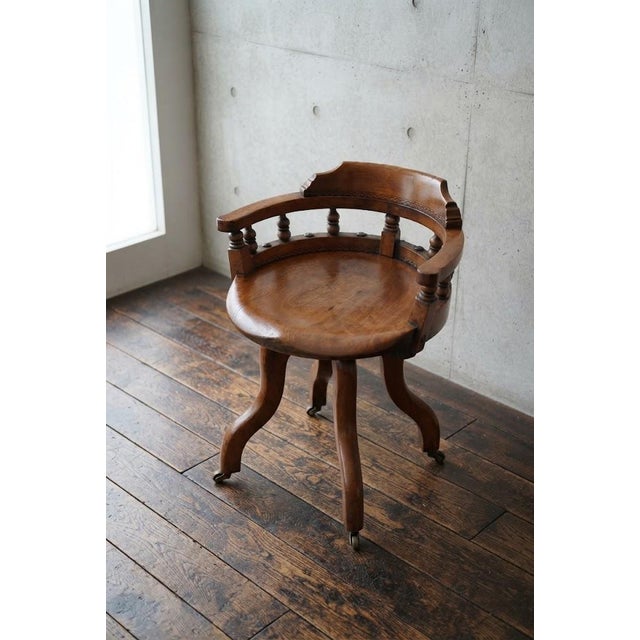 An exceptionally stylish and comfortable aesthetic movement revolving desk chair in solid walnut, combining artistic...