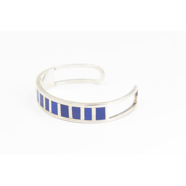 Sterling Silver and Lapis Lazuli Inlay Cuff Bracelet A contemporary sterling silver cuff bracelet featuring a series of...