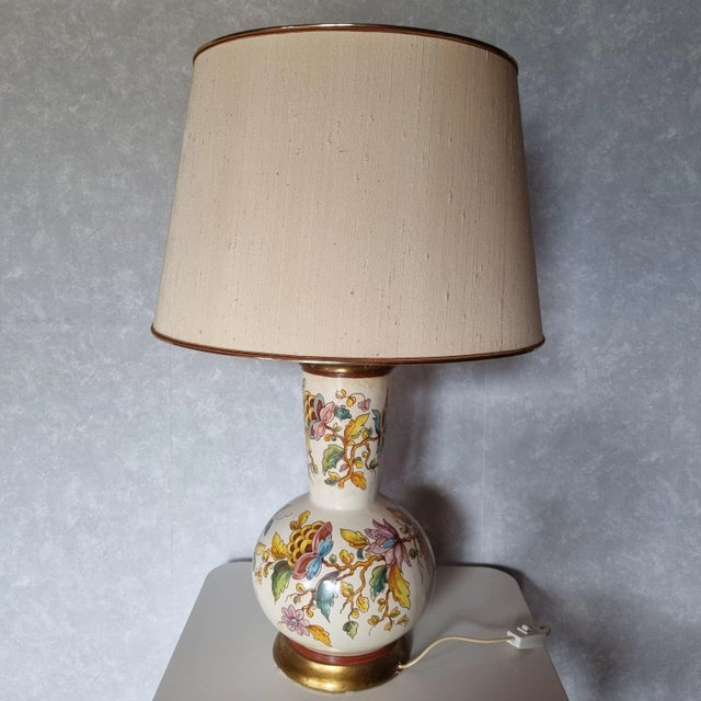 1950s ceramic desk lamp with hand-painted foliage decoration. Gilded wood base and collar: some signs of handling in...