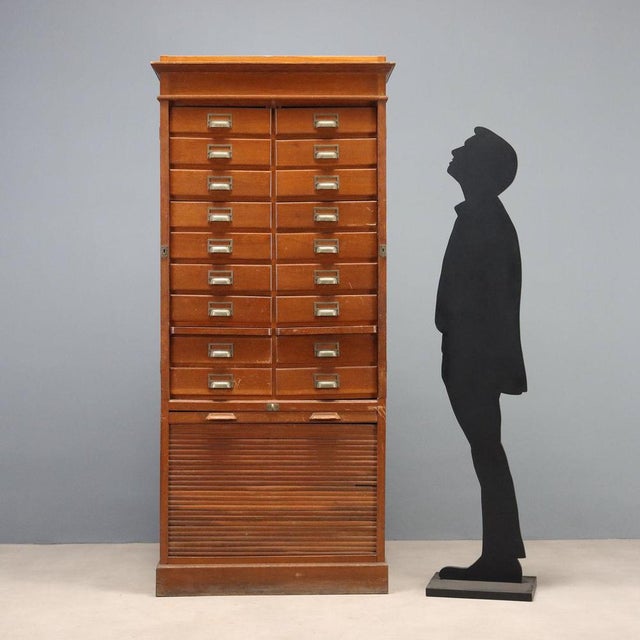 Art Nouveau oak filing cabinet. The front features 18 drawers with drop-fronts, arranged on two columns and equipped with...