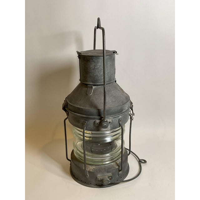Nautical ships lantern with fresnel glass lens. Steel case with brass "Anchor" and "Meteorite" badges. Hinged cap on...