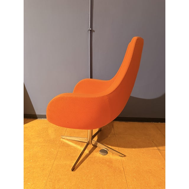 An elegant, original armchair from the 1970s, featuring soft, enveloping lines typical of the modernist design of the era....