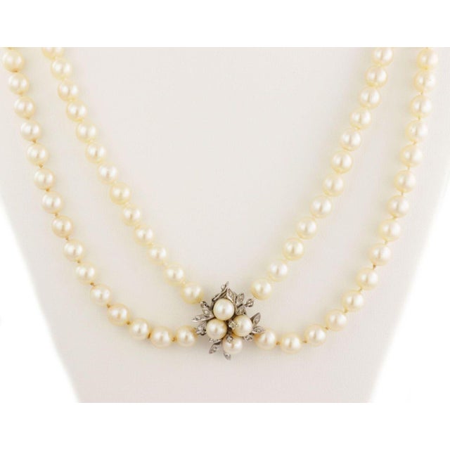 This lovely vintage necklace features a double strand creamy cultured pearls approximately 8mm. The strands are attached a...