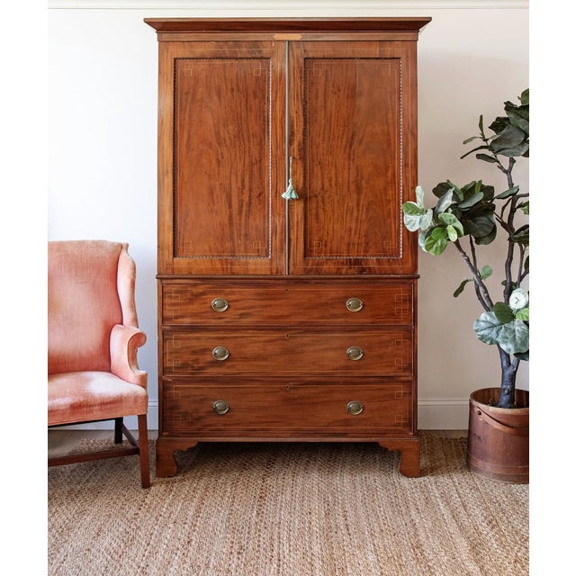 A beautifully proportioned early 19th-century mahogany linen press featuring rich book-matched veneers, fine line inlay,...