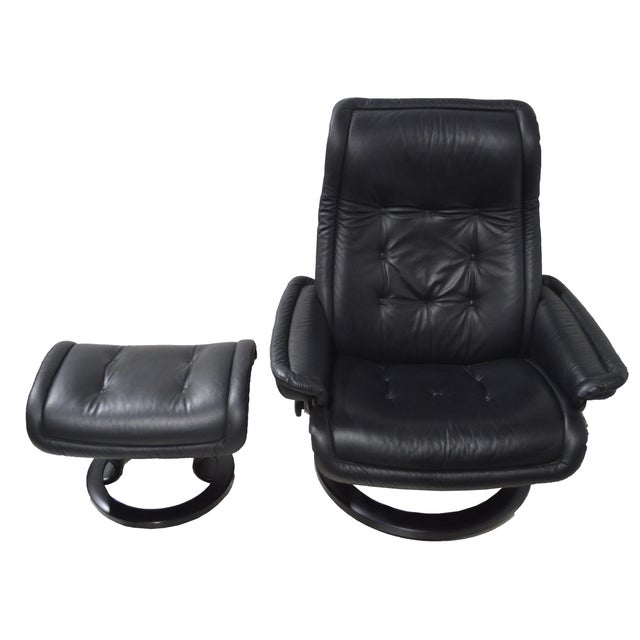 An Ekornes Stressless lounge chair with matching ottoman in black tufted / bolstered leather. A very fine chair designed...