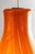 Pendant lamp from the Anemone series with an elongated (bulb-shaped) diffuser in translucent glass with orange rods....