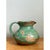 This vintage earthenware pitcher presents a full, rounded belly that rises to a gently narrowed neck and a softly pinched,...