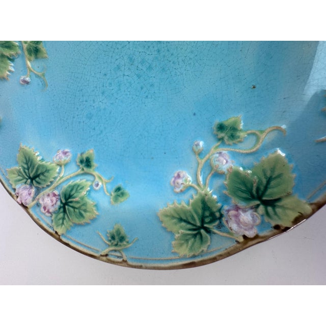 An individual English Majolica Plate. This is adorned with berry blossom fruits along the rim. The ground is a beautiful...