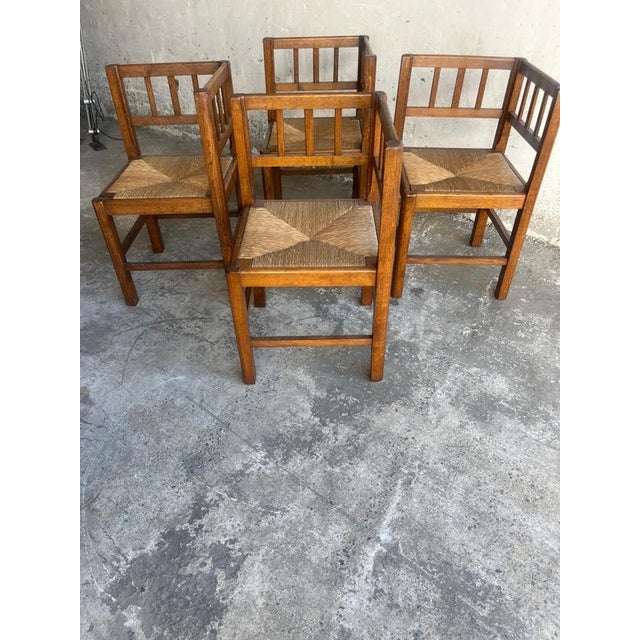 A beautiful set of four solid oak brutalist armchairs from the 1950s, featuring handwoven rush seats and a strong...