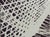 A signed and dated abstract pattern in neutrals that resembles a chaotic grid or net pattern. Characterized by organic,...