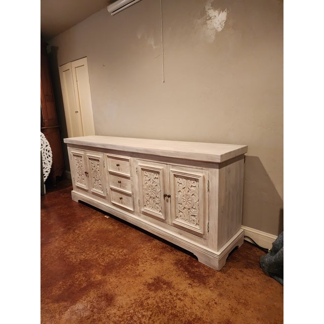 Large long whitewashed credenza with carved panels and heavy thick hardwood construction. Can be used in a variety of...
