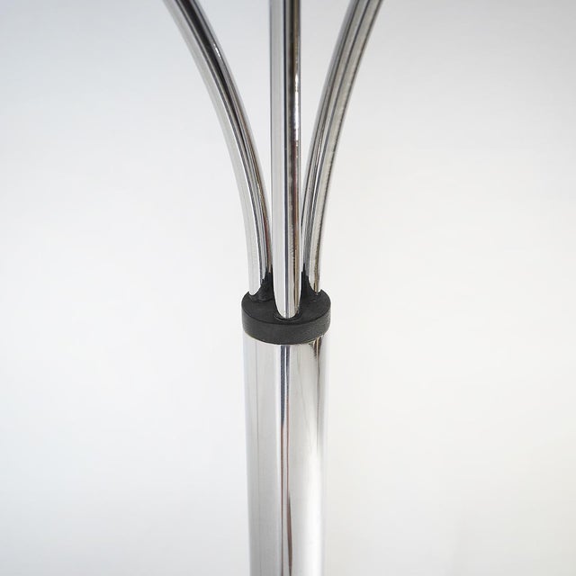 A three-arm chrome-plated metal floor lamp from the 1970s, a design that interprets light as a compositional element...