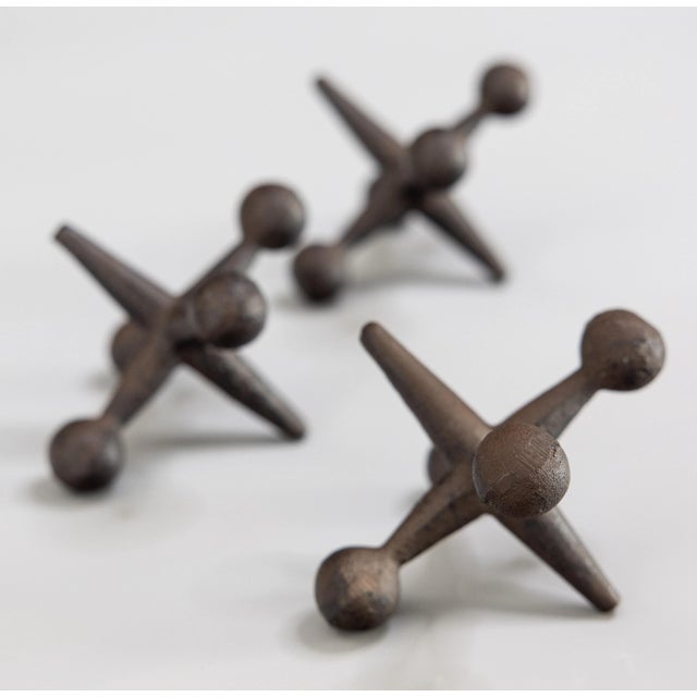 A stylish set of 3 Mid-Century Modern oversized heavy cast iron jacks with a lovely patina. They would be wonderful used...
