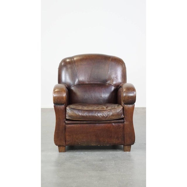 This spacious and in good condition dark sheep leather armchair/armchair with round shapes and a comfortable seat. This...