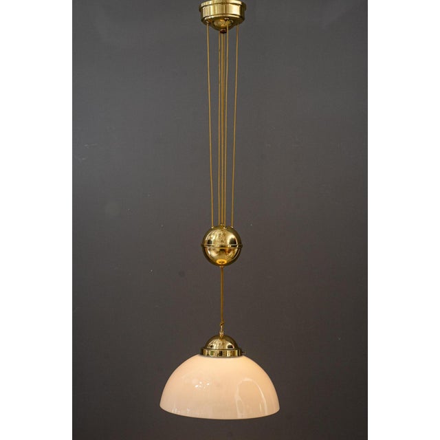 The height is adjustable from 94cm up to 180cm Brass polished and stove enameled Original old opal glass shade Up to 250V...