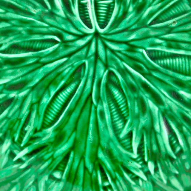 From Wedgwood, Burslem, England, a green majolica glazed shallow bowl server with a fringed leaf on a basket weave...