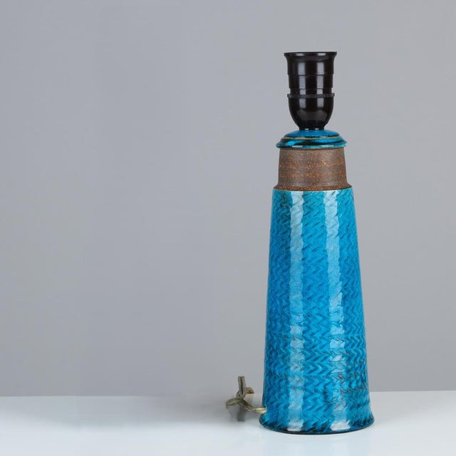 Table lamp made of partly blue-glazed stoneware with relief pattern. Signed “HA Nils Made in Denmark” on the bottom....