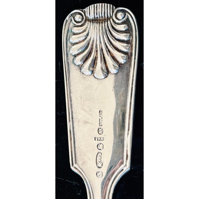 Large English EPNS silver serving spoon with shell motif and monogram ‘R’ on top of handle. Shell motif repeated on back...
