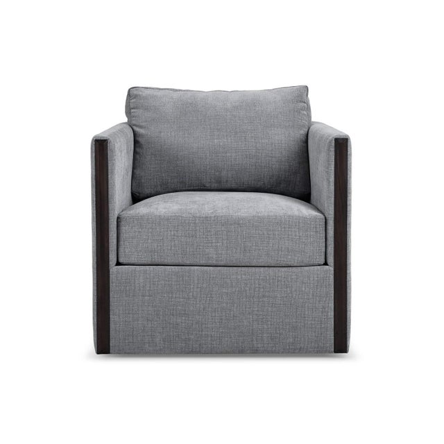 The swivel chair in gray upholstery balances architectural structure and modern comfort, defined by its clean-lined...