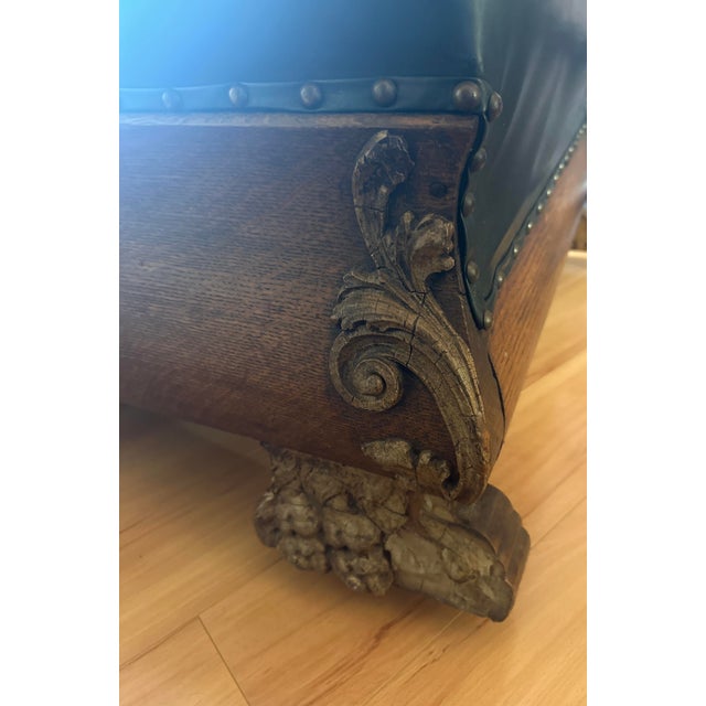 This is a dramatic carved oak chaise longue executed in a Renaissance Revival style, featuring a lion head crest at the...