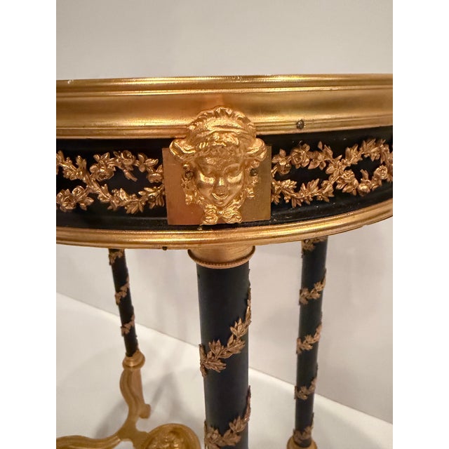 Superbly elegant and opulent bronze & marble gueridon oval table having incredible ornate details. The black and gold...