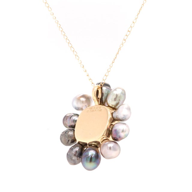Crafted in 14ct yellow gold, this pendant features a cushion‑cut aquamarine framed by a diamond halo and encircled by...