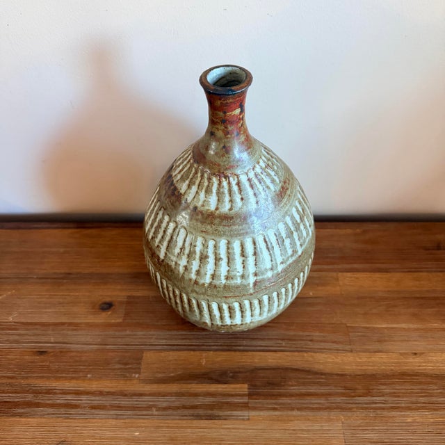 This mid-century studio stoneware bud vase has a beautiful sculptural form and a surface that really draws you in. The...
