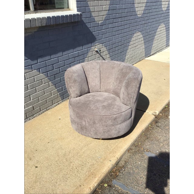 Freshly upholstered swivel lounge chair featuring a sculptural barrel form with softly channel-tufted back panels and a...