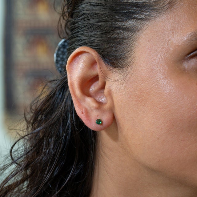 A matched pair of Zambian emeralds glows in lush green in these solid 14K gold martini solitaire stud earrings, available...