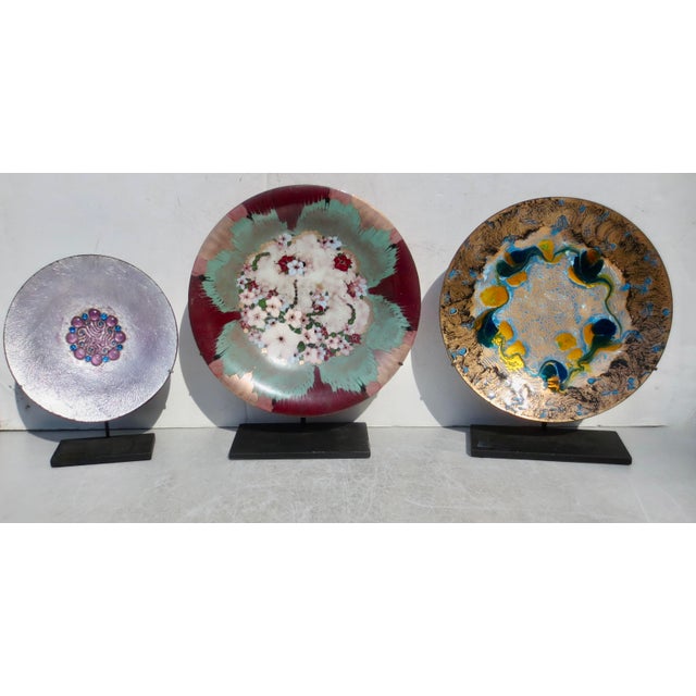 A beautiful assembled set of MCM enamel trays, steel-mounted displays of the brilliant color and play of flashing gold and...