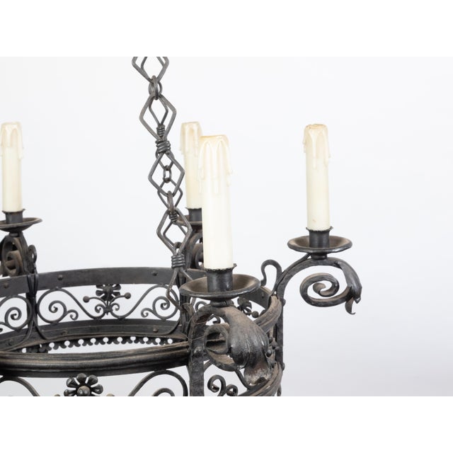 A French iron chandelier from the turn of the century, with six lights and scrollwork motifs. Created in France during the...