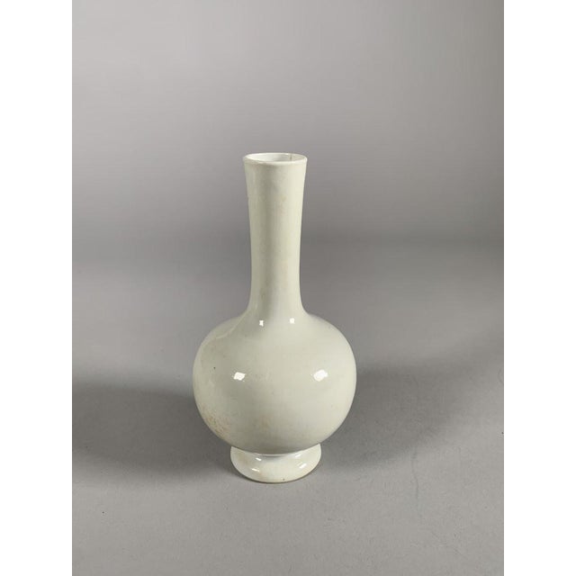 Monochrome white porcelain vase, Dehua kiln, Kangxi dynasty (1661-1722). Wide body resting on a foot and ending in a long...