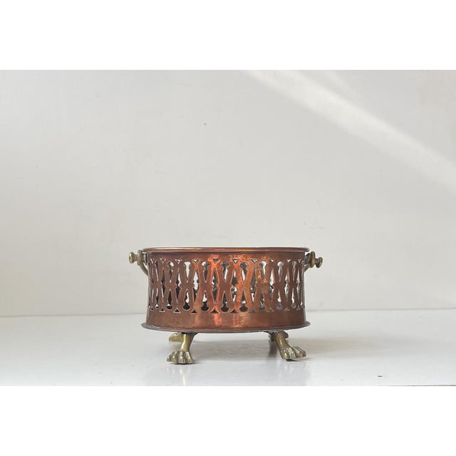 Perforated ovale basket or planter in copper featuring lion feet and handle in brass. European made circa 1890-1910s....