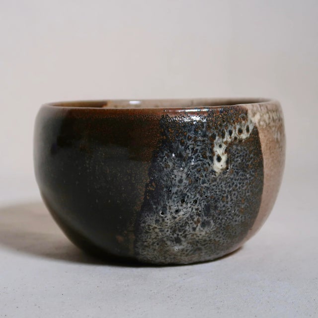 This handmade studio pottery bowl features a beautifully organic three-tone glaze composition that transitions from deep...