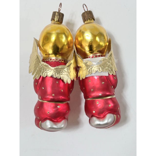 A pair of vintage German glass Christmas ornaments featuring kneeling angels with hands clasped in prayer. Each wears a...