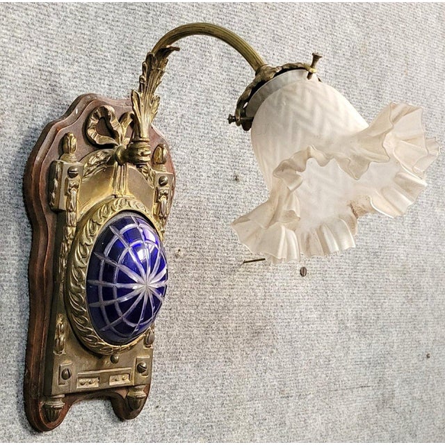 Louis XVI style wall sconce in bronze and cut crystal, circa 1880 decorated with ribboned bows and tassels solid wood base...