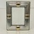 This is a lovely Chrome with Gold toned metal picture frame that will host a 3.25" X 4.5" image. The design is traditional...