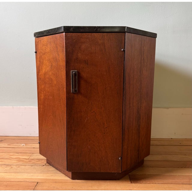 Mid century octagonal walnut side table with black marble top in the style of Harvey Probber. Lower cabinet opens to a...